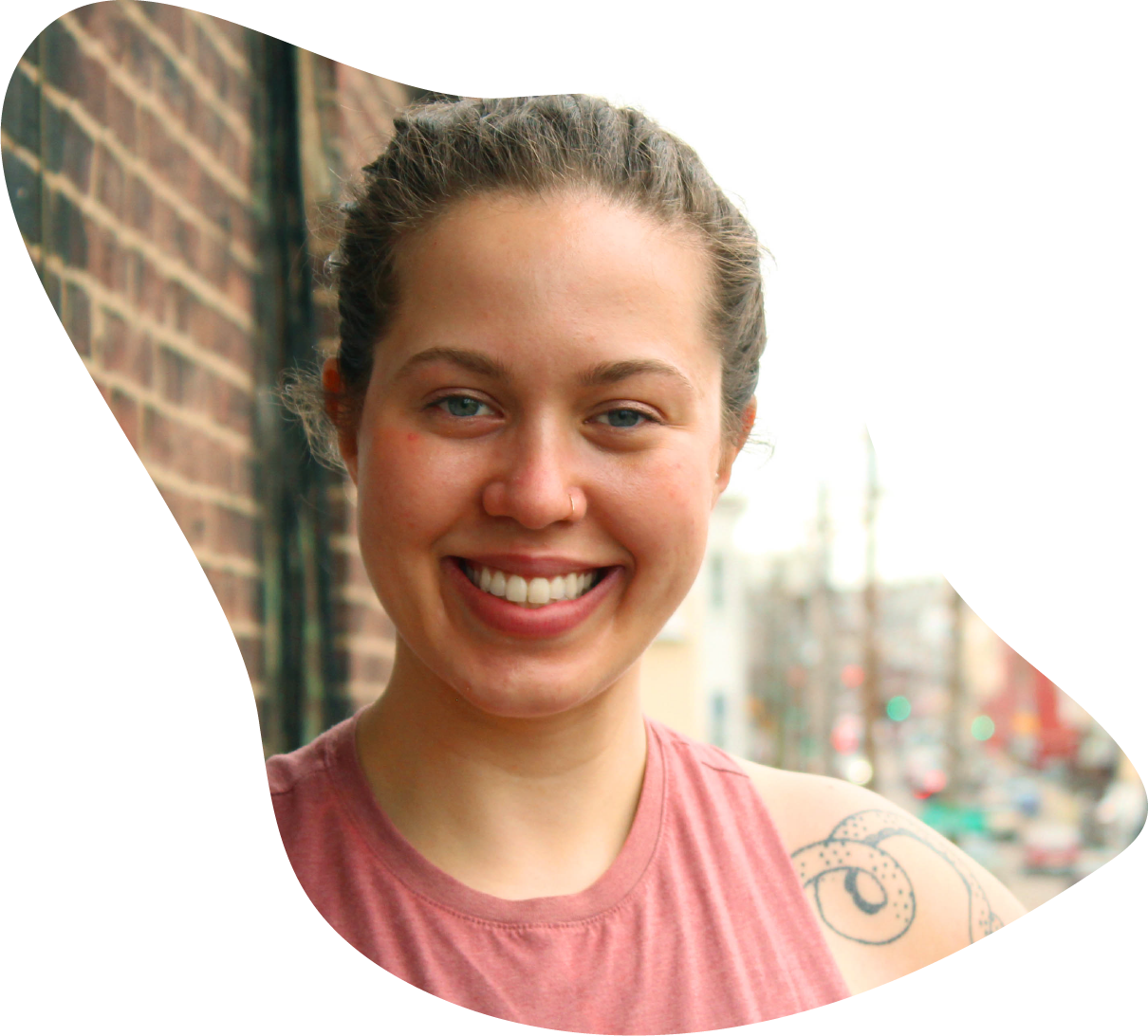  A headshot of Lydia, one of the three co-owners of Collective Strength. She is smiling and looking directly into the camera. She wears a pink tank top. 